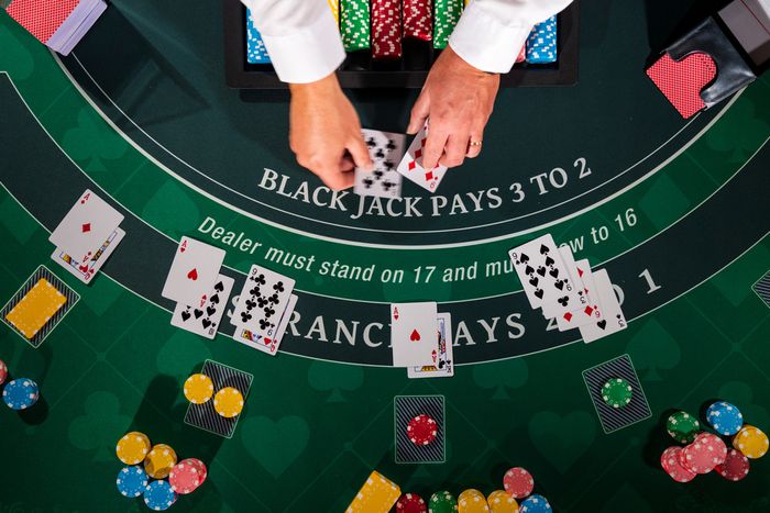 Dealer at a casino busy dealing a hand of blackjack to 4 different players